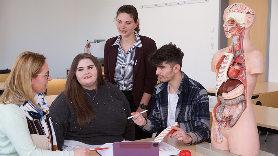 Kleine Lerngruppe Schüler und Schülerin mit zwei Lehrerinnen 