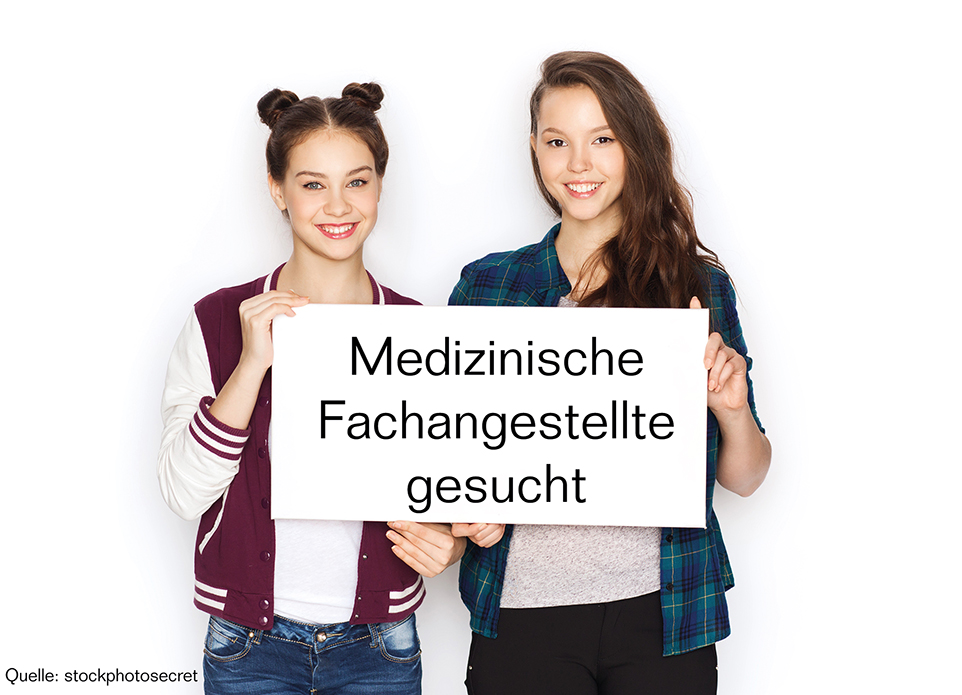 Zwei Personen halten ein Plakat in den Händen. Darauf ist die Aufschrift "Medizinische Fachangestellte gesucht".