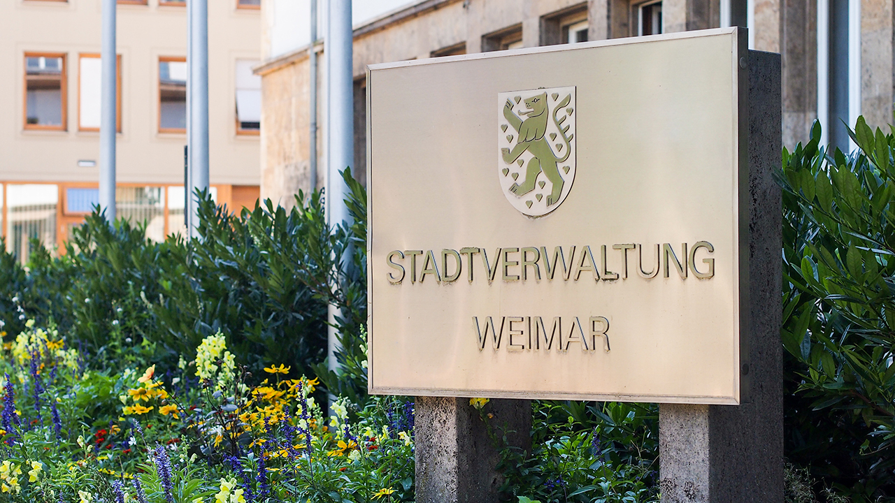 Das Schild der Stadtverwatung vor einem Blumenbeet