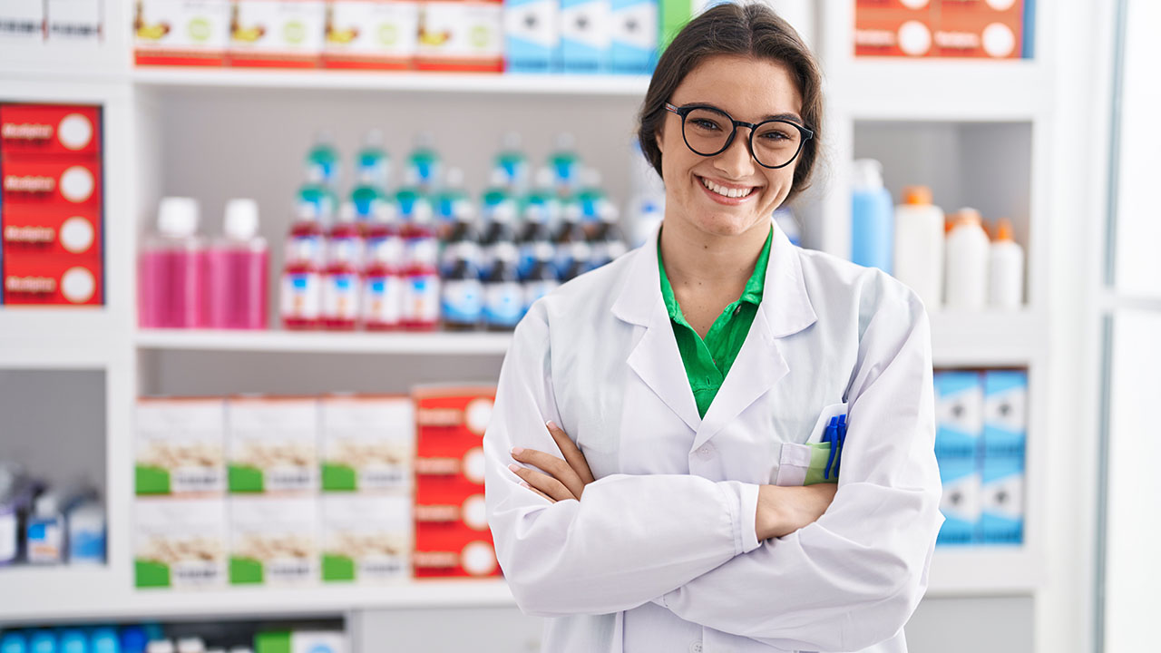 Frau in Apotheke vor Regal mit Medikamenten