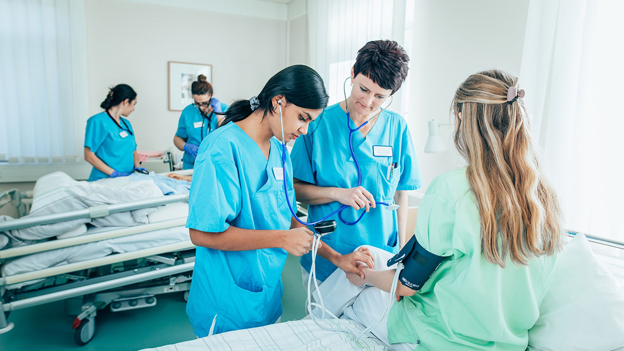 Krankenhaus-Mitarbeitende beim Blutdruckmessen