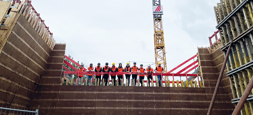 Mitarbeitende von Becker Bauunternehmen mit Westen und Helm auf einer Baustelle
