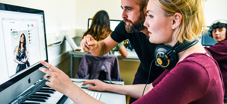 Zwei junge Menschen vor dem Computer