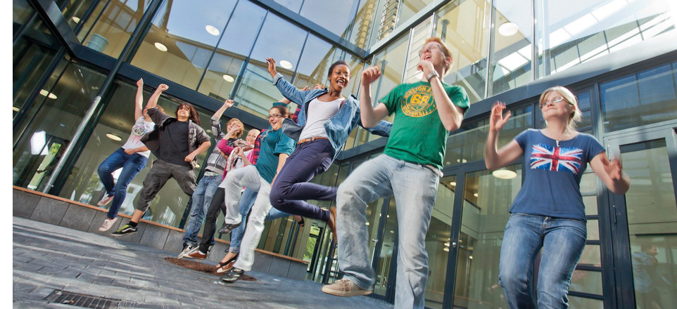 Personengruppe springt vor Freude in die Luft.
