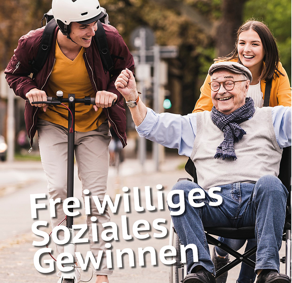 Mann im Rollstuhl wird geschoben. Neben ihm ein Mann auf einem Tretroller