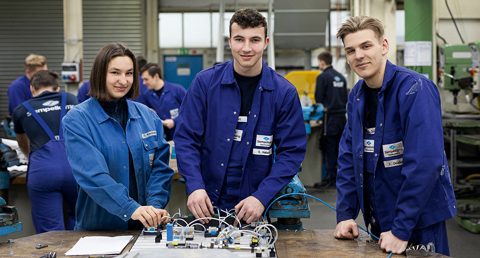 3 Personen in blauen Arbeitsanzügen