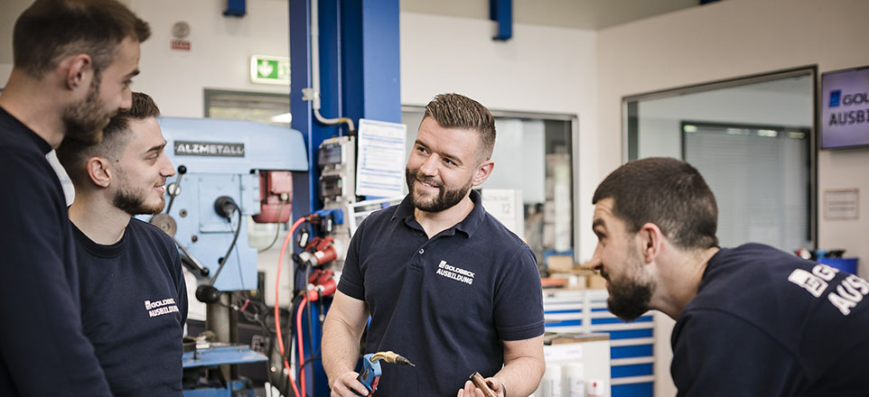 Vier Personen vor elektronischen Geräten.