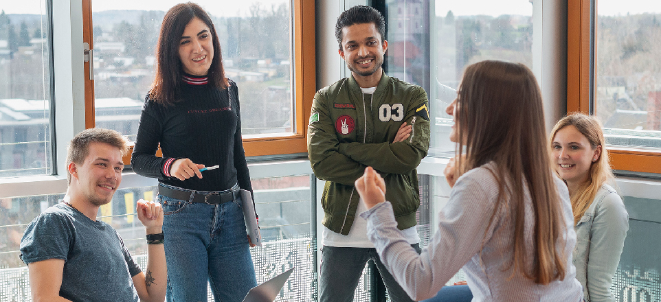 lockere Gesprächssituation zwischen Dozentin und vier Studierenden
