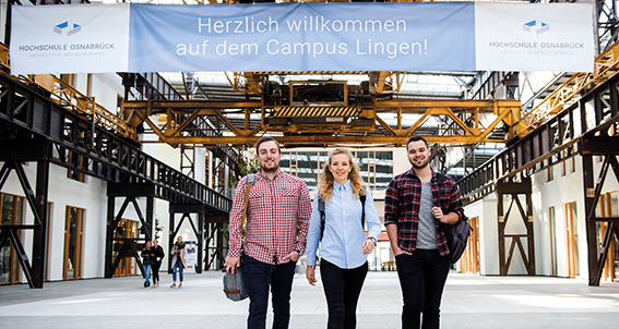 Studierende der Hochschule Osnabrück vor einem Banner mit der Aufschrift: Herzlich willkommen auf dem Campus Lingen! 