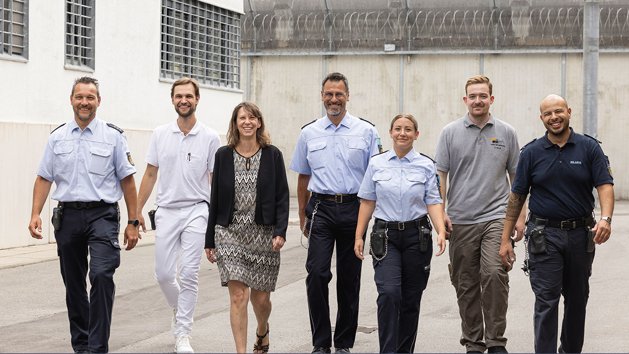 Sieben Personen in unterschiedlicher Dienstkleidung.
