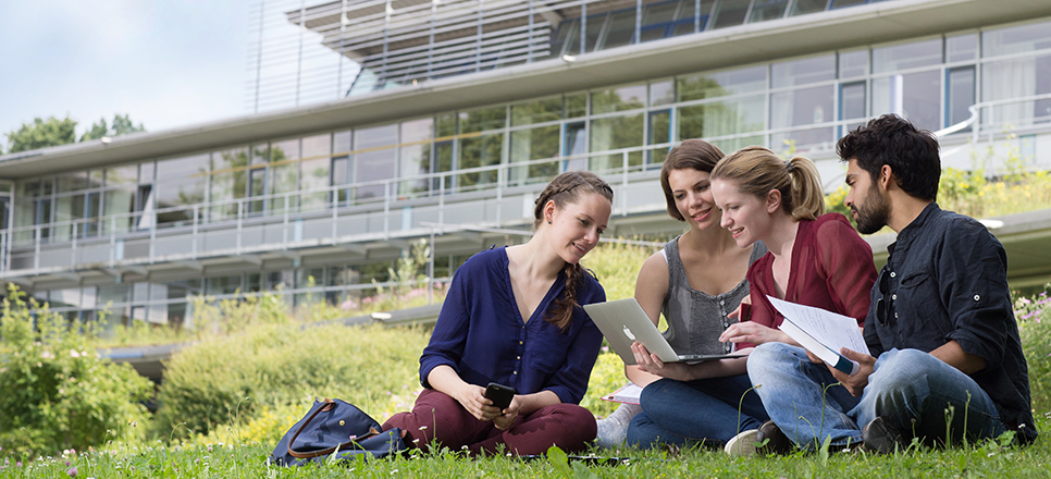 Junge Menschen vorm Uni-Gebäude
