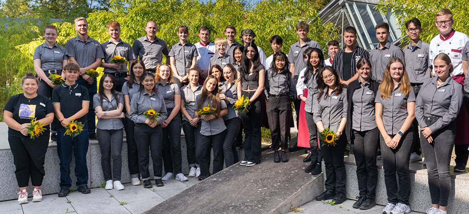 Gruppenbild, einige Personen mit Blumensträußen