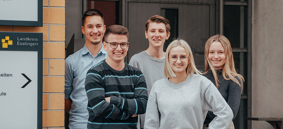 Vier junge Menschen stehen vor dem Landratsamt Esslingen und lächeln in die Kamera