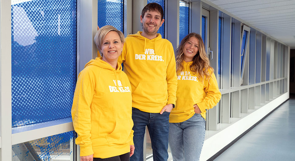 3 Personen in gelben Hoodies
