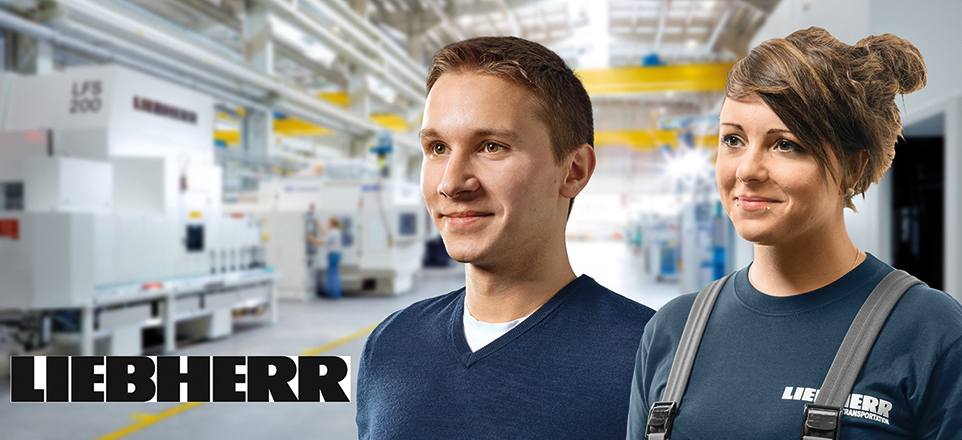 Zwei Personen lächeln im Hintergrund ist eine Werkshalle zu sehen. 