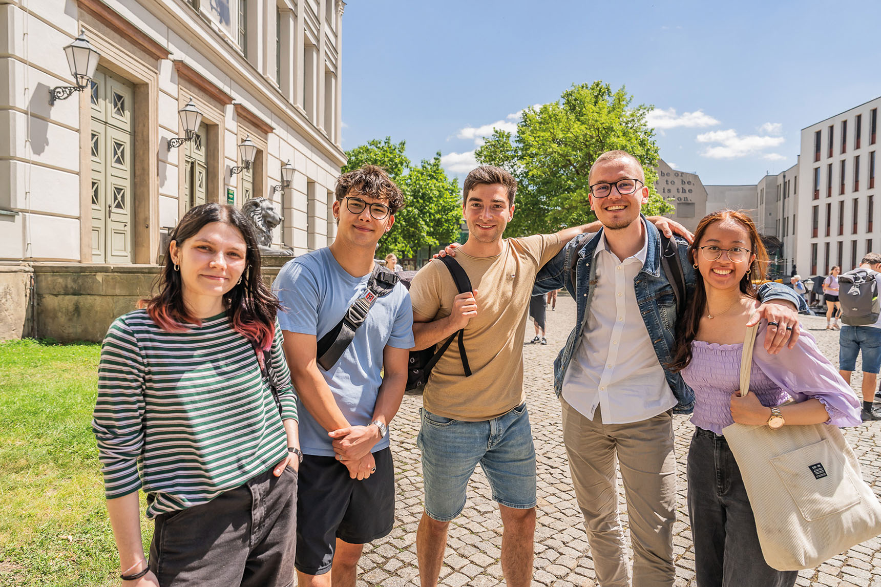 Gruppenbild von fünf Studenten vor dem Löwengebäude