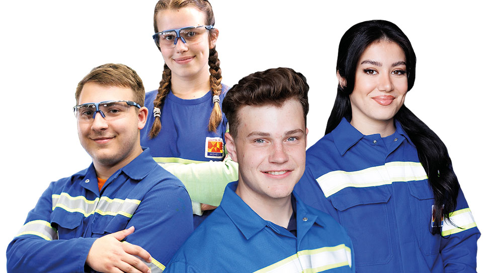 Vier Azubis in blauer Arbeitskleidung