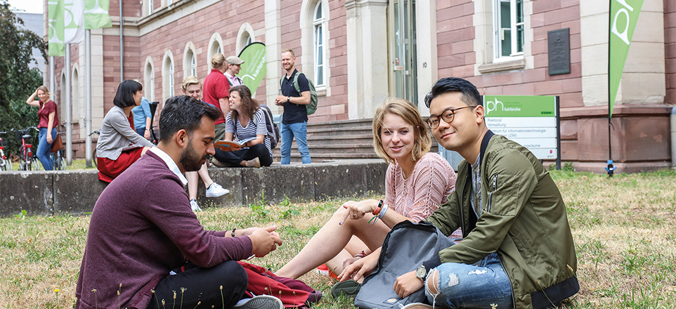 Personen im Vordergrund, im Hintergrund der Campus.