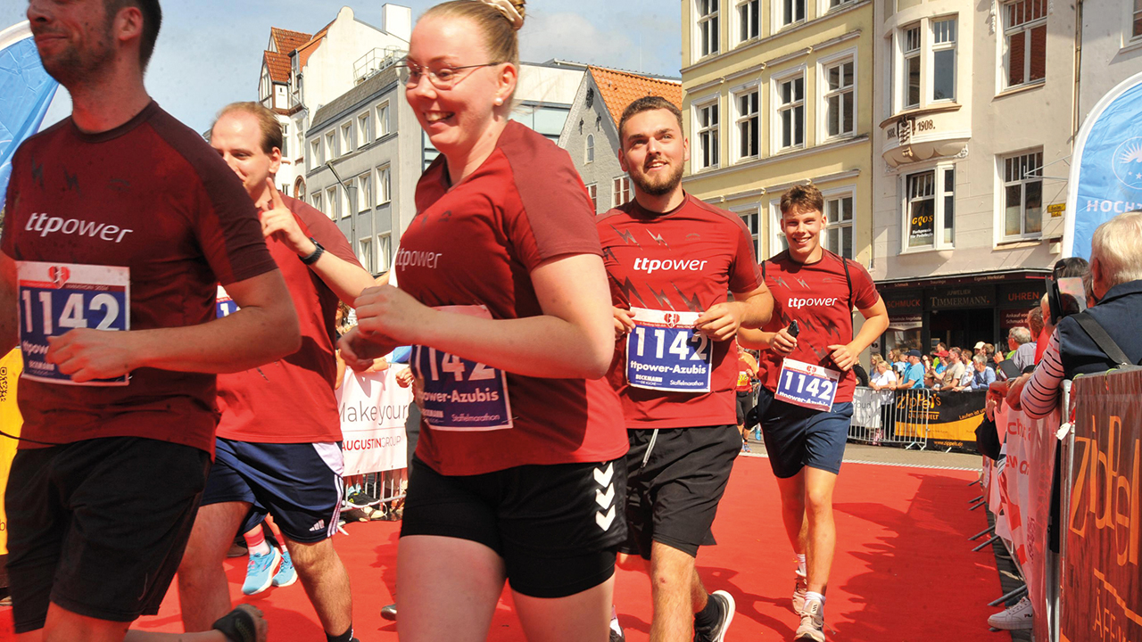 Junge Menschen bei einem Lauf, die rote Shirts von TTP mit Startnummern tragen
