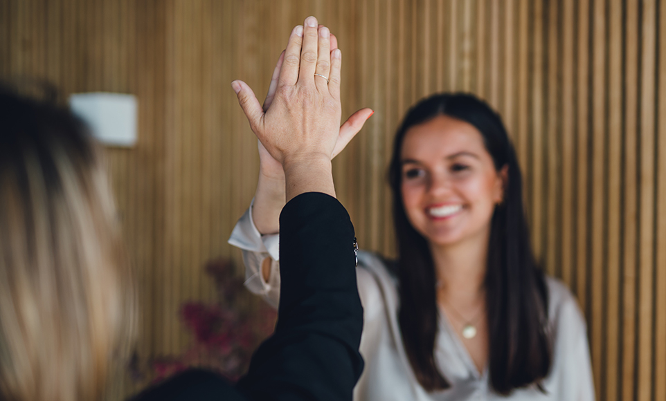 Zwei Personen mit langen Haaren geben sich ein High five
