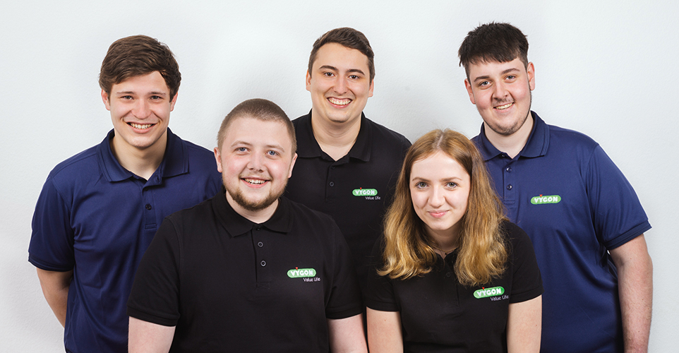 Gruppenbild von 5 jungen Menschen in scharzen und dunkelblauen Poloshirts