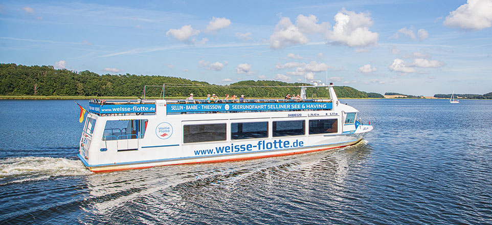 Ein Schiff mit der Aufschrift "www.weisse-flotte.de" fährt im Wasser.